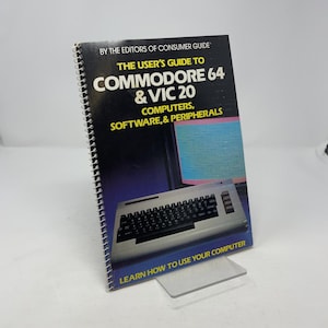 May include: A spiral-bound book titled "The User's Guide to Commodore 64 & VIC 20" with a keyboard illustration. The cover is black with blue and purple gradients. The text "Learn How to Use Your Computer" is at the bottom.
