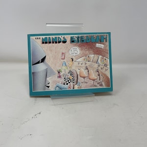 May include: A cartoon print with a teal border, titled "The Mind's Eyebeam", shows a retro-futuristic scene. A figure in a checkered shirt relaxes in a chair, while another figure in a hooded robe looms nearby. The print includes the text "Lighten up buddy, it's all in your head."