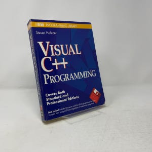 May include: A blue paperback book titled Visual C++ Programming by Steven Holzner, part of the Brady Programming Library. The cover features white and red text, a graphic of a floppy disk, and states it covers both standard and professional editions.