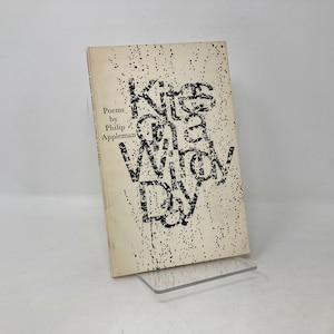 May include: A book titled "Kites in the Windy Day" by Philip Appleman. The title is printed in black and white on a white background with a speckled pattern.