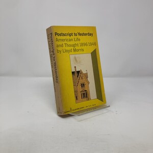 Könnte beinhalten: Ein gelbes Buch mit dem Titel "Postscript to Yesterday: American Life and Thought 1896 1946 by Lloyd Morris". Der Buchumschlag zeigt eine Schwarzweißillustration eines Hauses.
