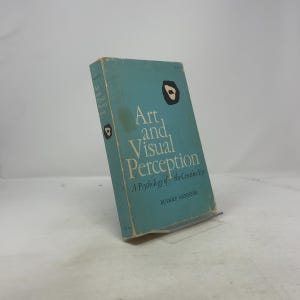 Op de afbeelding: Een boek met een turquoise omslag met de titel "Art and Visual Perception" van Rudolf Arnheim. Het boek heeft witte en zwarte grafische elementen. De titel is wit, met daaronder de ondertitel "A Psychology of the Creative Eye".