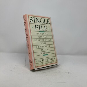 May include: A pink and white book titled "Single File: How to Live Happily Forever After With or Without Prince Charming" by Susan Deitz with Anne Cassidy.
