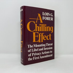 Pode incluir: Um livro de capa dura cor vinho tinto com o título "A Chilling Effect: The Mounting Threat of Libel and Invasion of Privacy Actions to the First Amendment" de Lois G. Forer.