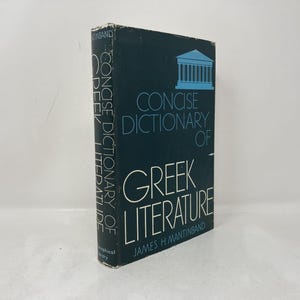 Peut inclure: Un livre à couverture rigide intitulé "Concise Dictionary of Greek Literature" par James H. Mantinband. Le livre a une couverture bleu foncé avec du texte blanc et bleu clair et un dessin d'un bâtiment.