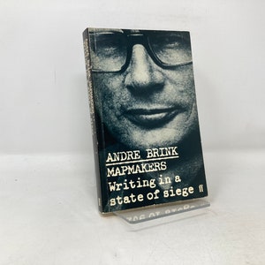 May include: A black and white photo of a man wearing glasses is on the cover of a book titled "Writing in a state of siege" by Andre Brink. The book is about mapmakers.