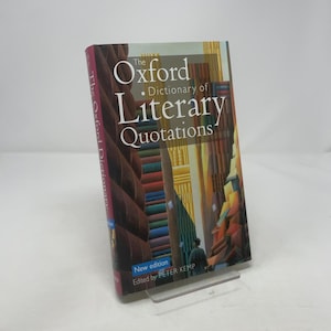 Puede incluir: El Diccionario Oxford de Citas Literarias, nueva edición, editado por Peter Kemp. La portada del libro presenta una colorida ilustración de una biblioteca y una persona caminando. El lomo dice "The Oxford Dictionary".