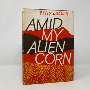 May include: A vintage paperback book titled "Amid My Alien Corn" by Betty Lussier. The cover features a red and brown landscape with white text.