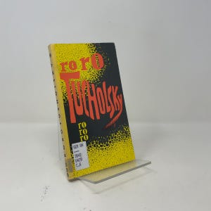 Può includere: Un libro tascabile con copertina gialla e nera caratterizzata da un motivo a puntini. Il titolo recita roro TUCHOLSKY in grandi lettere rosse, con il testo roro più piccolo sotto. Un'etichetta bianca da biblioteca è in basso a sinistra.