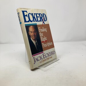 Puede incluir: Un libro blanco con el título "Eckerd Finding the Right Prescription" de Jack Eckerd y Charles Paul Conn. La portada del libro presenta una foto de Jack Eckerd.