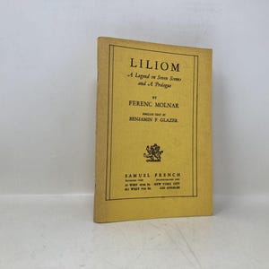 Può includere: Un libro d'epoca intitolato "Liliom" di Ferenc Molnar. La copertina gialla presenta testo nero e un emblema decorativo. È un'opera teatrale in sette scene e un prologo, pubblicata da Samuel French.