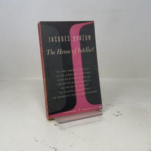 May include: A paperback book titled The House of Intellect by Jacques Barzun. The cover features a black background with a pink vertical graphic, thin white lines forming circular patterns, and white text listing chapter titles in a serif font.