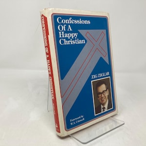 Puede incluir: Un libro titulado "Confessions of a Happy Christian" de Zig Ziglar con un diseño de flecha azul y roja en la portada. El libro tiene un prólogo de W.A. Criswell.