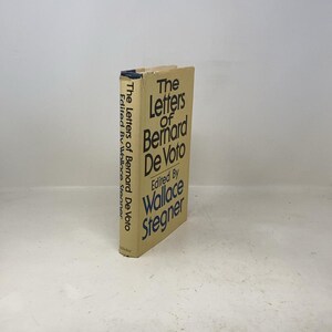 Peut inclure: Un livre à couverture rigide intitulé "The Letters of Bernard De Voto", édité par Wallace Stegner. La couverture beige présente un texte noir et bleu. Le titre et le nom de l'auteur sont visibles sur la tranche.