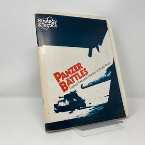 May include: A vintage copy of "Panzer Battles" from the "Strategy & Tactics" series. The cover features a dark blue and white design with the title in red and a tank illustration. The book focuses on tactical armored warfare in World War II.