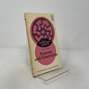 May include: A paperback book titled Kosmos und Geschichte by Mircea Eliade. The off-white cover features a large pink circle containing a dark circular geometric symbol, with the text rowohlts deutsche enzyklopädie and the publisher logo roro.
