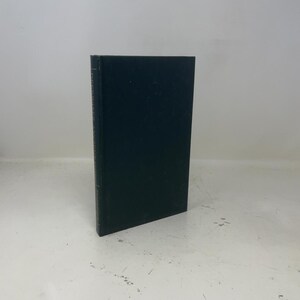 May include: A hardcover book with a dark teal cover. The spine has text in a lighter color. The book is standing upright against a white background. The book appears to be in good condition.