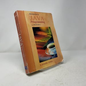 Op de afbeelding: Een leerboek getiteld Introduction to Java Programming with JBuilder 5 door Y. Daniel Liang. De kaft heeft een achtergrond met een warm kleurverloop en een afbeelding van een computertoetsenbord en een witte koffiekop op een schoteltje.