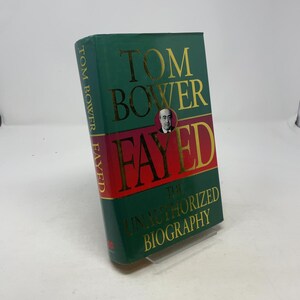 May include: A hardcover book titled "Tom Bower Fayed: The Unauthorized Biography." The book has a green cover with gold lettering and a red stripe. A portrait of a man is featured on the cover.