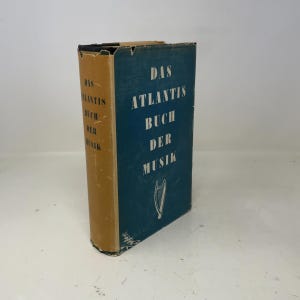 Pode incluir: Um livro vintage intitulado "Das Atlantis Buch Der Musik" com capa azul e lombada dourada. A capa apresenta texto branco e uma ilustração de harpa. A lombada do livro também tem texto. O livro está em bom estado.