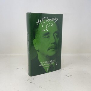 May include: A dark green hardback book titled Experiment in Autobiography Volume II by H.G. Wells. The front cover features a large, monochromatic portrait of H.G. Wells in a lighter shade of green, with his signature printed in white above the face.