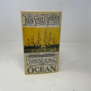 May include: A hardcover book titled "A Thread Across the Ocean" by John Steele Gordon. The cover features an illustration of sailing ships and the text "The Heroic Story of the Transatlantic Cable."