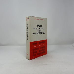 May include: A vintage book titled "Basic Electricity for Electronics" is displayed. The book has a white cover with red accents and text. The cover features the title and author's name. The book is standing upright.