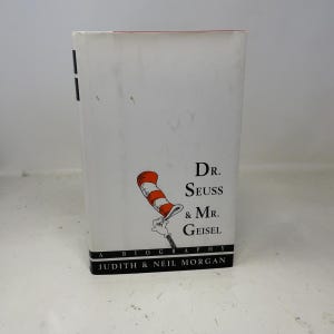 May include: A hardcover book with a white cover featuring the title "Dr. Seuss & Mr. Geisel" and a drawing of the Cat in the Hat's hat. The book is a biography by Judith & Neil Morgan.