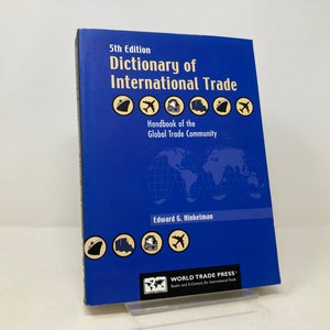 Könnte beinhalten: Ein blaues Buch mit dem Titel "Dictionary of International Trade" 5. Auflage, Handbuch der globalen Handelgemeinschaft von Edward G. Hinkelman. Der Buchumschlag zeigt eine Weltkarte, Flugzeuge, Schiffe, LKWs und Züge.