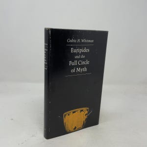 May include: A black hardcover book titled Euripides and the Full Circle of Myth by Cedric H. Whitman. The front cover features white text and a gold-colored illustration of an ancient vessel at the bottom. The spine is also black with white text.