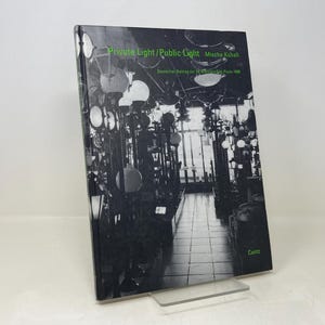 May include: A black and white photo of a book cover titled "Private Light/Public Light" by  Micha Kubal. The cover features a black and white photo of a hallway with many light fixtures.