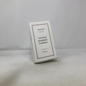 Peut inclure: Un livre blanc intitulé "Les Tchèques (Bohémiens) en Amérique" de Thomas Capek. Le livre a une bordure rouge et est présenté sur un présentoir en acrylique transparent. Le titre du livre est en police serif.