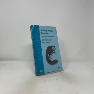 May include: A light blue hardback book titled Shaping Primate Evolution: Form, Function and Behaviour, edited by Fred Anapol, Rebecca Z. German and Nina G. Jablonski. The cover features a black and white illustration of a lemur-like primate.