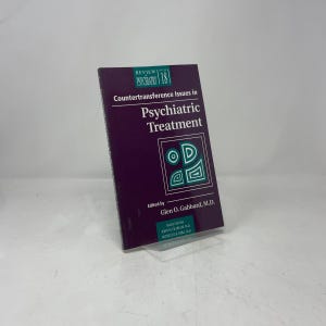 May include: A hardcover book titled "Countertransference Issues in Psychiatric Treatment" with a dark purple cover. The book has white text and a geometric design. The book is edited by Glen O. Gabbard, M.D.