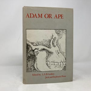 Puede incluir: Un libro titulado "Adán o Simio" con una ilustración en blanco y negro de un cráneo en la portada. El libro está editado por L.S.B Leakey, Jack y Stephanie Prost.