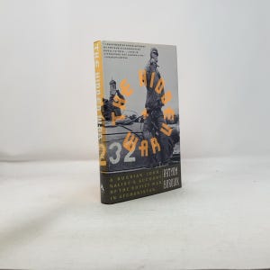 May include: A hardcover book titled "The Hidden War" by Artyom Borovik. The cover features a black and white image of soldiers with orange text overlaying the image. The spine is yellow.