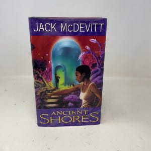 Può includere: Un libro con il titolo "Ancient Shores" di Jack McDevitt. La copertina presenta una donna che si protende verso un portale luminoso, con un uomo in lontananza. Lo sfondo ha tonalità viola e rosse.