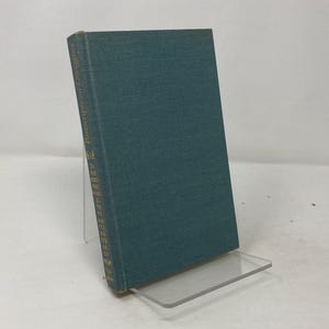 Könnte beinhalten: Ein tealblaues Hardcover-Buch mit einem weißen Rücken.