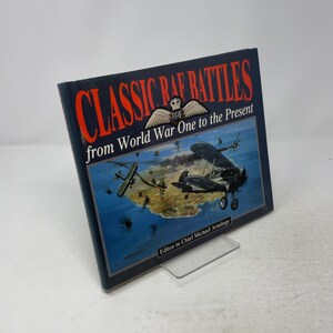 May include: A hardcover book titled Classic RAF Battles from World War One to the Present, edited by Michael Armitage. The dark blue cover features large red text, a white RAF emblem, and an illustration of biplanes flying over a coastline.