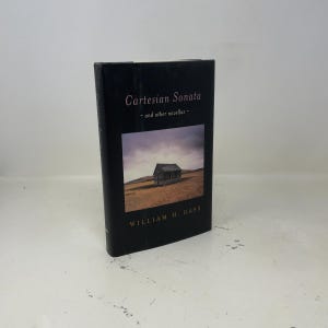 May include: A hardcover book titled "Cartesian Sonata - and other novellas -" by William H. Gass. The book has a black cover with white text and a landscape image of a small building on a hill.