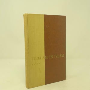 May include: A hardcover book titled Judaism in Islām by Katsh, featuring a two-tone cover design with a light yellow spine and front panel section, and a larger dark brown panel on the right side. The title and author name are printed in gold.