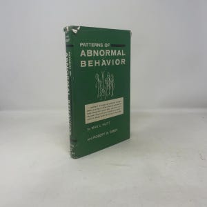 May include: A green book titled "PATTERNS OF ABNORMAL BEHAVIOR" with white text. The book has a graphic of stick figures and is by Max L. Hutt and Robert & Gibby. The book's spine also displays the title.