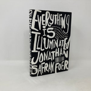 May include: A black book with white text that reads "Everything is Illuminated" by Jonathan Safran Foer.