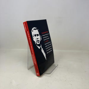 May include: A hardcover book titled "Fortunate Son" with a black cover featuring a white portrait and text. The book's spine is red with white text. The book is about George W. Bush and the making of an American President.
