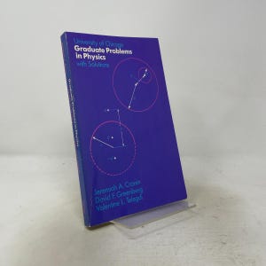 May include: A purple paperback book titled University of Chicago Graduate Problems in Physics with Solutions by Jeremiah A. Cronin, David F. Greenberg, and Valentine L. Telegdi. The cover features light blue text and pink circular diagrams.