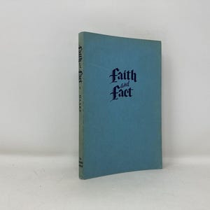 May include: A light blue book titled "Faith and Fact" with ornate lettering. The book is standing upright against a white background. The book's spine has the title and author's name.