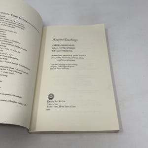 May include: An open book titled Dakini Teachings: Padmasambhava's Oral Instructions to Lady Tsogyal. The page displays text regarding the recording, revealing, and translation of the work, with the Rangjung Yeshe Publications logo and 1999 date.
