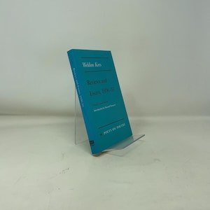 May include: A teal book titled "Reviews and Essays, 1936-55" by Weldon Kees, part of the "Poets on Poetry" series. The book is displayed on a clear acrylic stand against a white background.