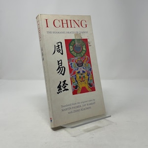 May include: A hardcover book titled "I Ching" with the subtitle "The Shamanic Oracle of Change." The cover features Chinese characters and a colorful illustration. The book is translated by Martin Palmer, Jay Ramsay, and Zhao Xiaomin.