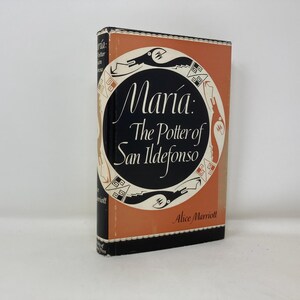 May include: A hardcover book titled "María: The Potter of San Ildefonso" by Alice Marriott. The book has an orange and black cover with a circular design and the title in white script. The spine is black.